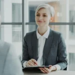 Seorang perempuan profesional mewawancarai kandidat di ruang kantor modern untuk proses rekrutmen